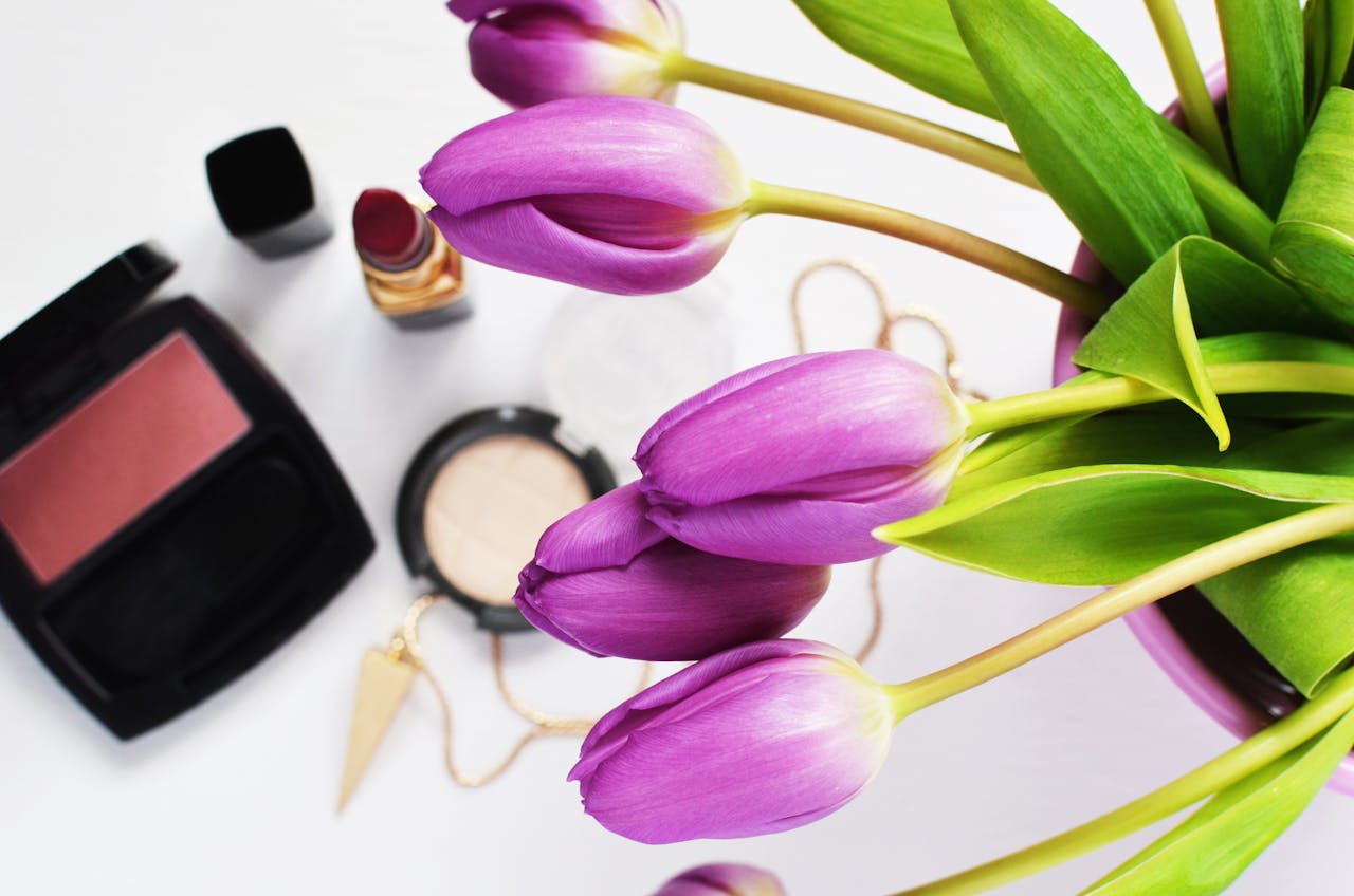 The Art of Drawing Readers In: Your attractive post title goes here Purple tulips and makeup create a stylish beauty flat lay.